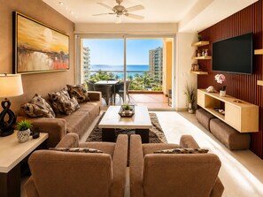 A modern living room with a sofa, coffee table, TV, and a balcony with a view of the sea.