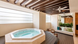 A modern spa area with a hot tub, wooden flooring, and a seating area with plants. - Luxury Beachfront Condo at Del Canto Residences with Beautiful Ocean Views (Nuevo Vallarta)