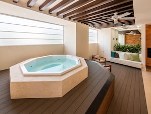 A modern spa area with a hot tub, wooden flooring, and a seating area with plants. - Luxury Beachfront Condo at Del Canto Residences with Beautiful Ocean Views (Nuevo Vallarta)