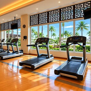 A gym with treadmills, large windows, and a view of palm trees. - Luxury Beachfront Condo at Del Canto Residences with Beautiful Ocean Views (Nuevo Vallarta)