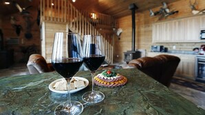 A wooden interior with a dining table featuring two wine glasses and a decorated cake. - Edenwood Ranch Private SQ MILE (Wautoma)