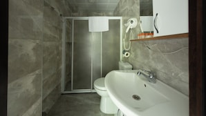 Un baño con ducha, inodoro y lavamanos.