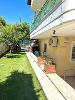 Un edificio con balcón, mobiliario exterior y macetas.