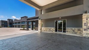 A modern building with a covered entrance, stone accents, and a clear sky. - Porter Inn (Porter)