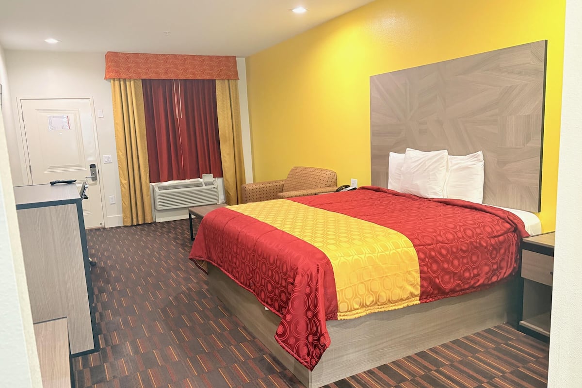 Una habitación de hotel con una cama grande, un escritorio y una silla.