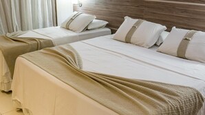 A hotel room with two beds, each with white bedding and beige throw blankets. - Rapport Hotel (Juazeiro)