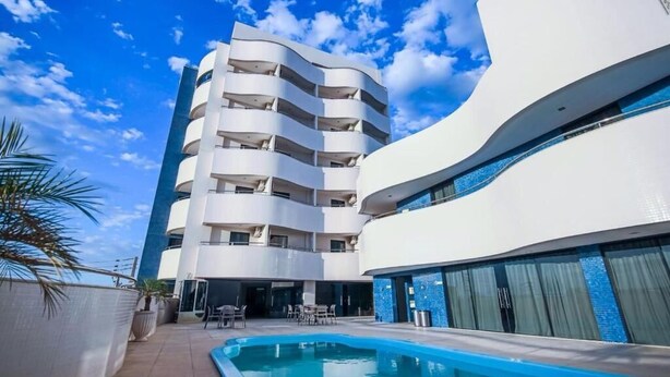 A modern hotel with a pool, a curved white building, and a multi-story structure with balconies. - Rapport Hotel (Juazeiro)