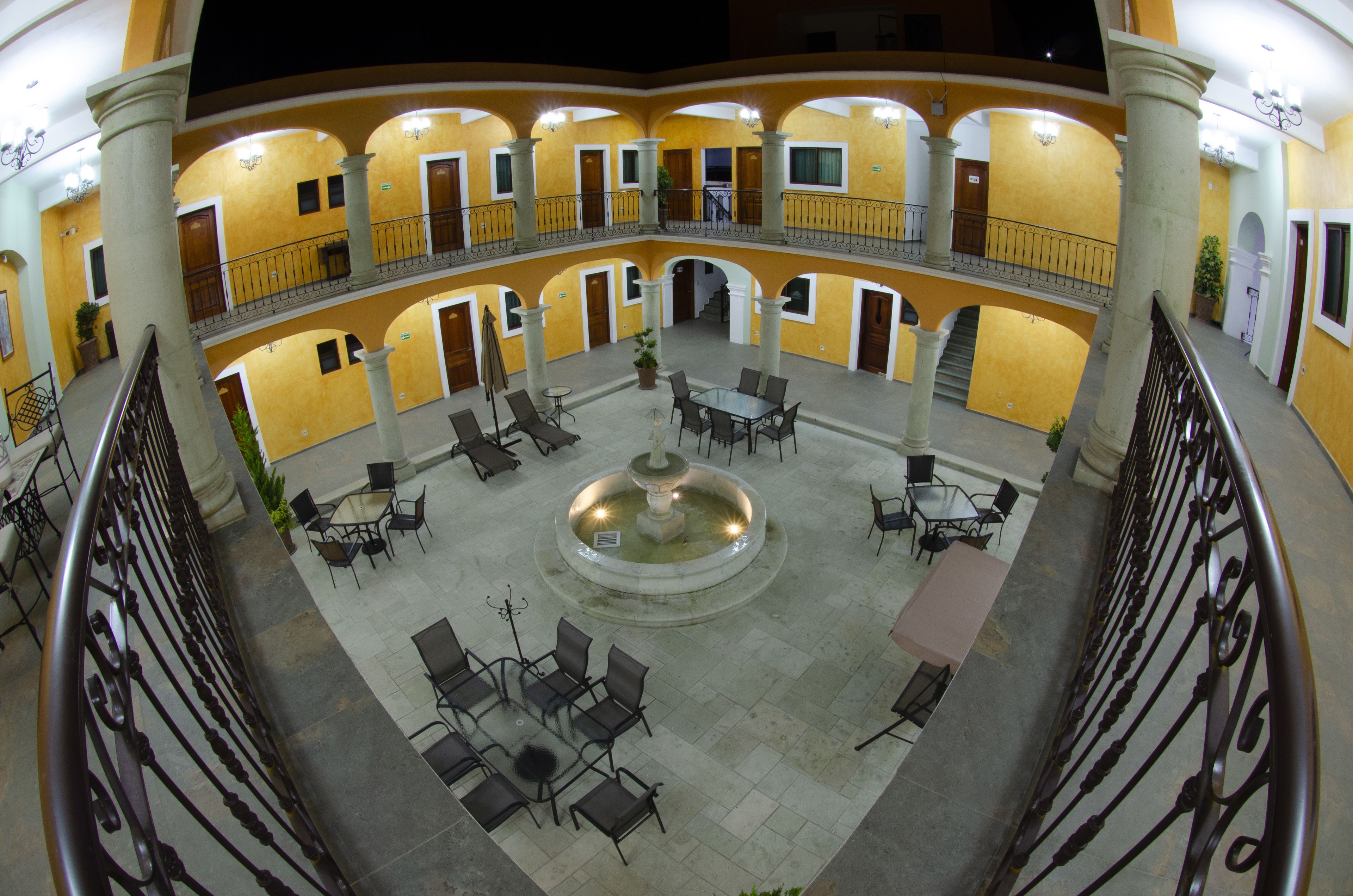 A multi-level courtyard with a central fountain, surrounded by seating areas and balconies.