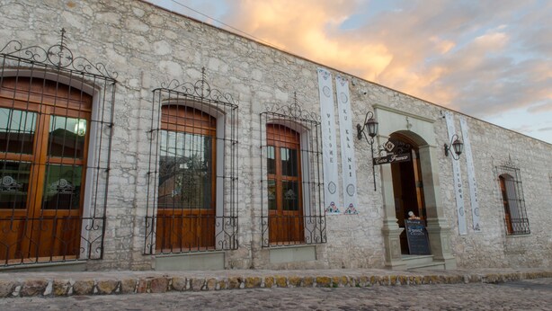 Un edificio de piedra con ventanas arqueadas y barandillas de hierro forjado.