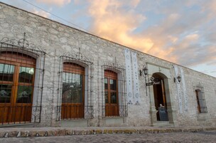 A stone building with arched windows and wrought iron railings.