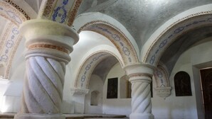 Interior con techos abovedados y columnas, destacando diseños elaborados y un suelo sencillo.