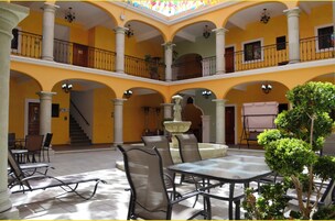 A multi-level courtyard with a central fountain, seating areas, and a staircase leading to an upper level.