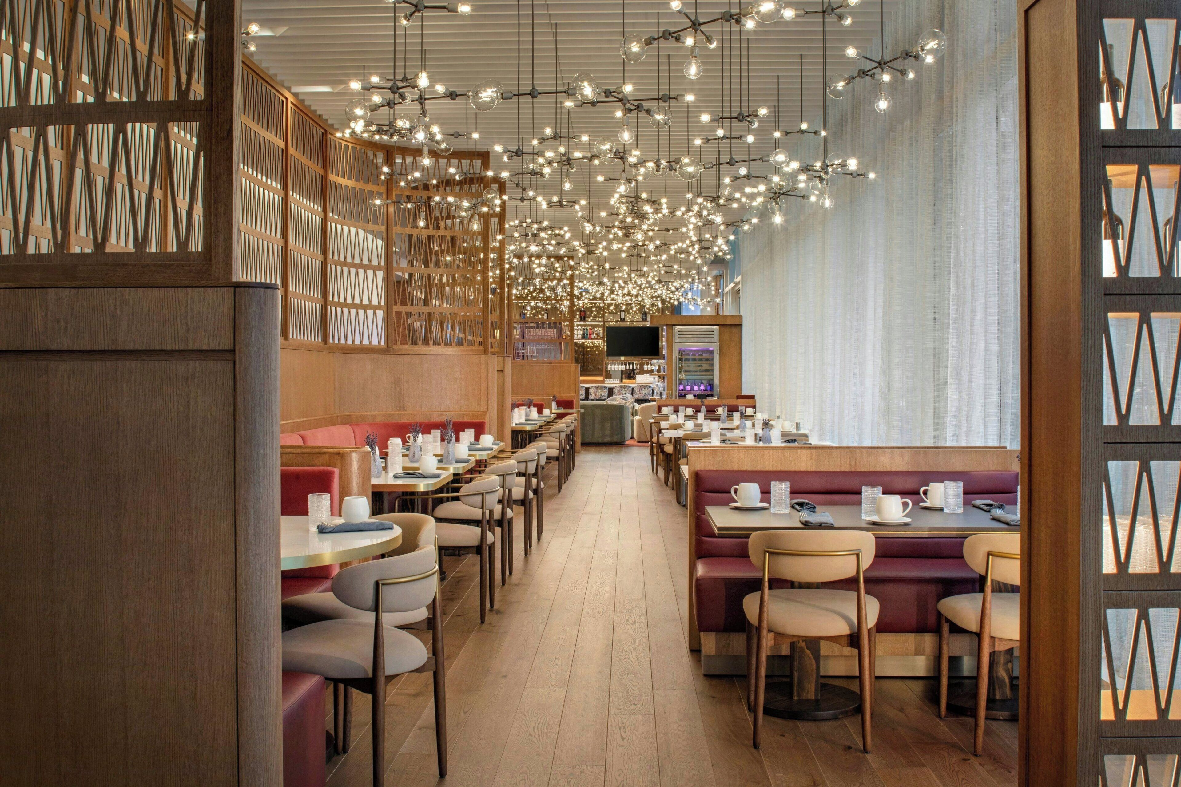 A restaurant with wooden paneling, hanging lights, and booths.