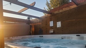 A hot tub with wooden walls and a ceiling structure. - Motel Tyrol (Radium Hot Springs)