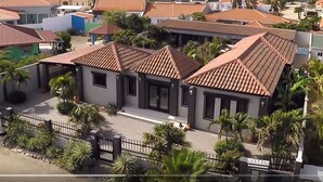 Zona residencial con casas de techos de tejas rojas y una entrada con portón.