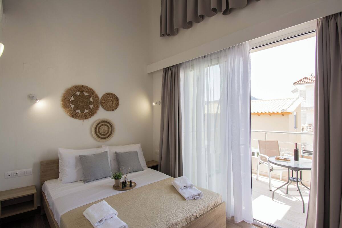 A hotel room with a bed, bedside table, and a view of the balcony.