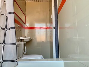 A bathroom with a toilet, sink, and shower area. - Hotel Plateros (Cusco)