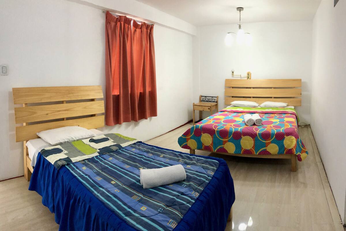 Une chambre à coucher avec deux lits, chacun recouvert d’une couvre-lit à motifs différents.