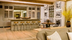 A modern kitchen with a central island, bar stools, and a dining area with a table and chairs. - Eleven Scarp Ridge Lodge (Crested Butte)
