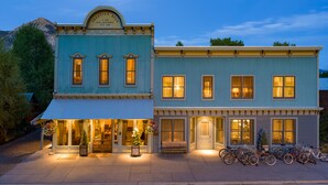 A two-story building with a blue facade, a sign reading "Croatian Hall Sub Assembly No 26," and a row of bicycles parked outside. - Eleven Scarp Ridge Lodge (Crested Butte)