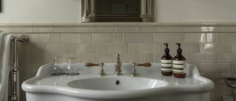 A bathroom with a white sink, two bottles of hand soap, and a mirror above the sink.