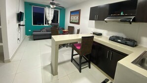 A compact living space with a dining area, kitchenette, and a TV mounted on the wall. - Jackuri Casa Hospedaje (San Andrés)