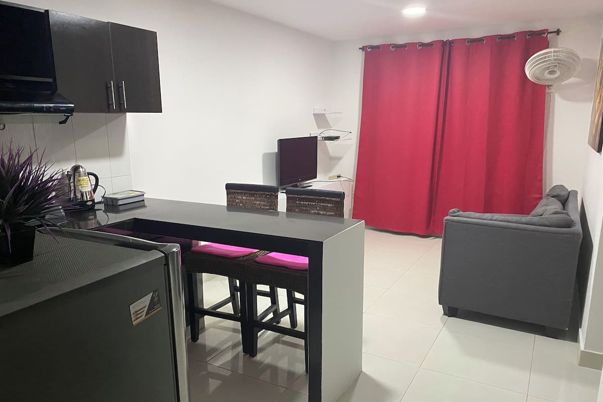 A compact living space with a kitchenette, a dining area, and a seating area.