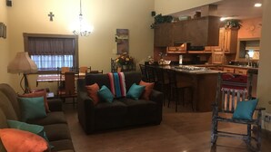 Un soggiorno con divano, poltrone e zona pranzo con tavolo e sedie.