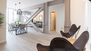 Un vaste espace de vie comprenant une table à manger, des chaises et un escalier.