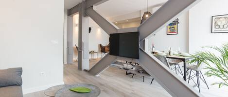 A modern living space with a staircase, a dining area, and a kitchen.