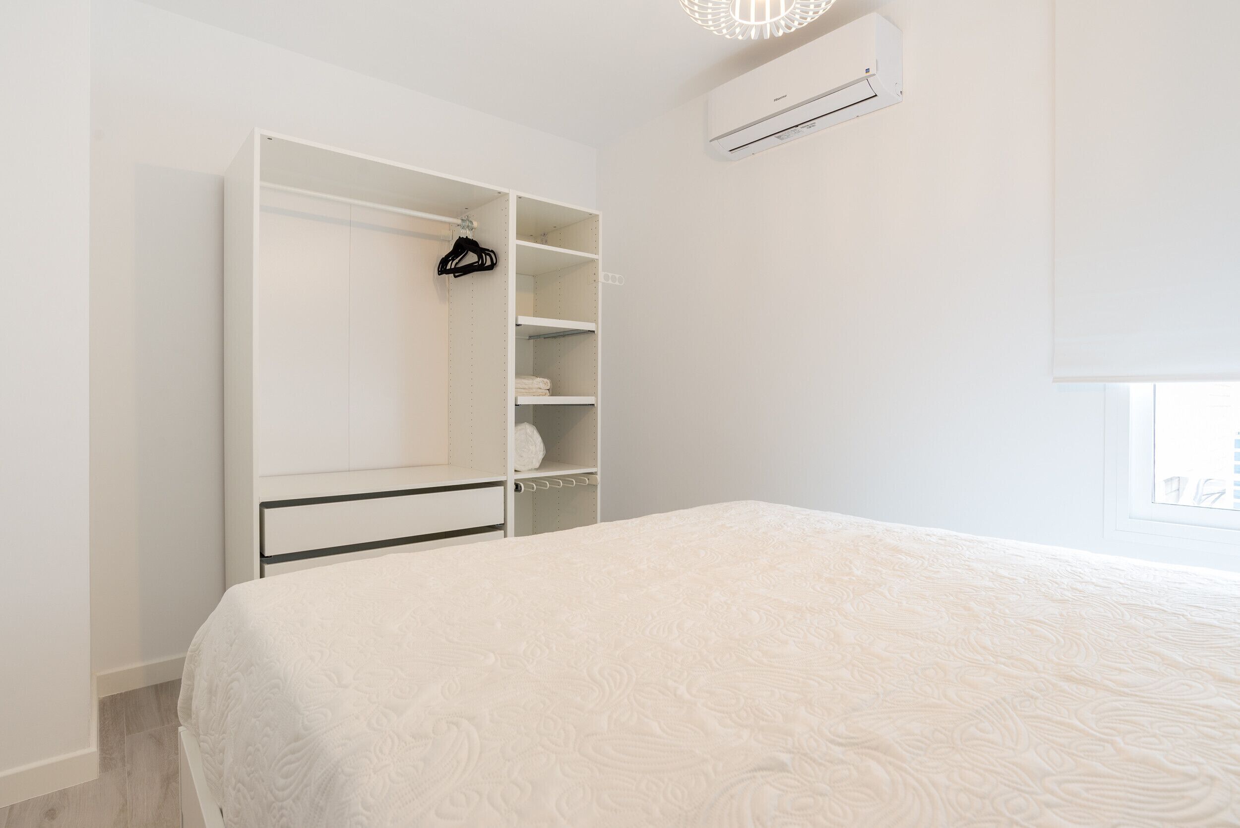 Ein Schlafzimmer mit einem Bett, einem Kleiderschrank und einer Klimaanlage.