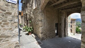 A stone building with a sign reading "Borgo di Mezzo".