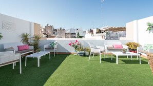 A rooftop terrace with white furniture, artificial grass, and potted plants. - Albareda 1 - One Bedroom Apartment, Sleeps 4 (Sevilla)