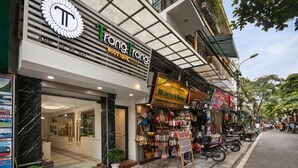 A boutique hotel with a modern facade, a visible entrance, and a variety of shops on the ground floor.