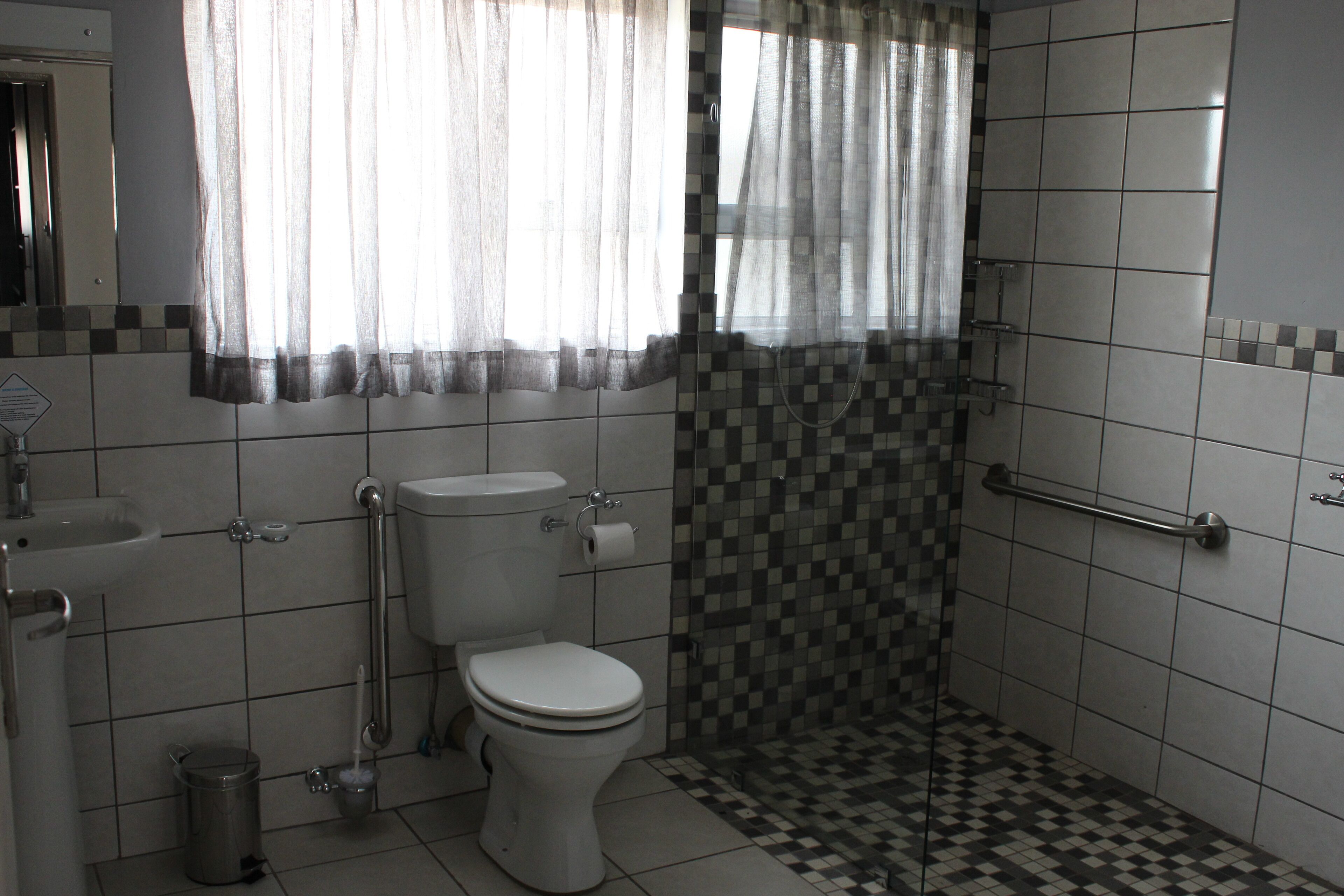 Un baño con inodoro, lavamanos y ducha.