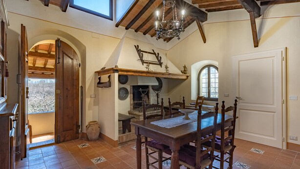 A rustic dining room with a wooden table and chairs, a chandelier, and a fireplace. - Beatrice - Charming accommodation in period farmhouse near Montepulciano (Chianciano Terme)