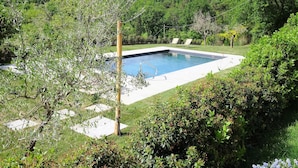 A rectangular swimming pool surrounded by lush greenery and a hillside. - Beatrice - Charming accommodation in period farmhouse near Montepulciano (Chianciano Terme)