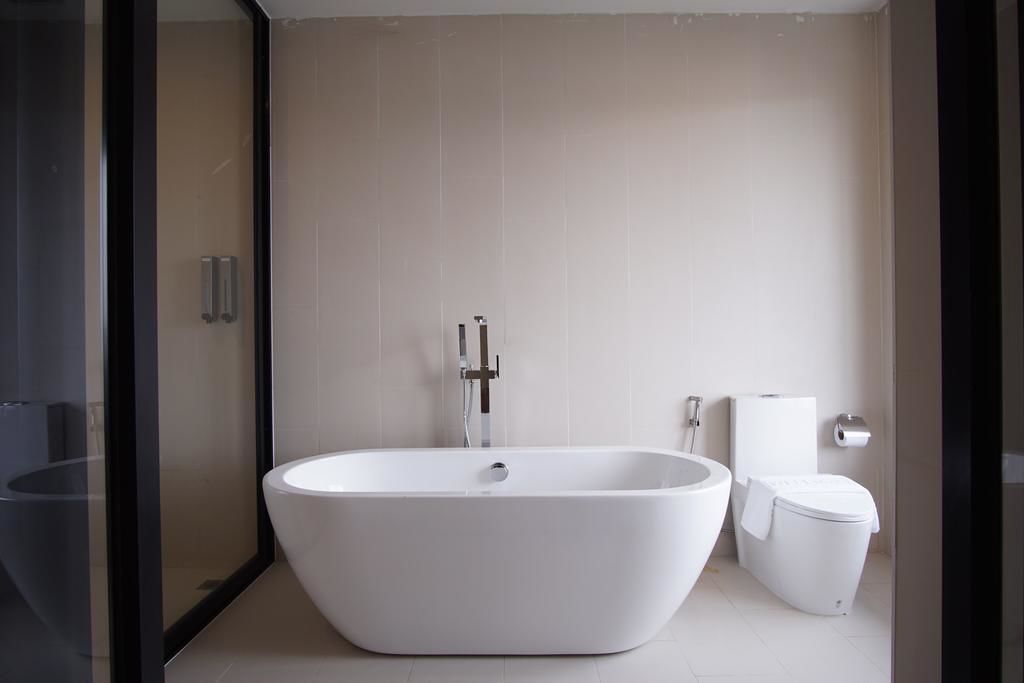 A modern bathroom with a freestanding bathtub, a toilet, and a glass shower enclosure.