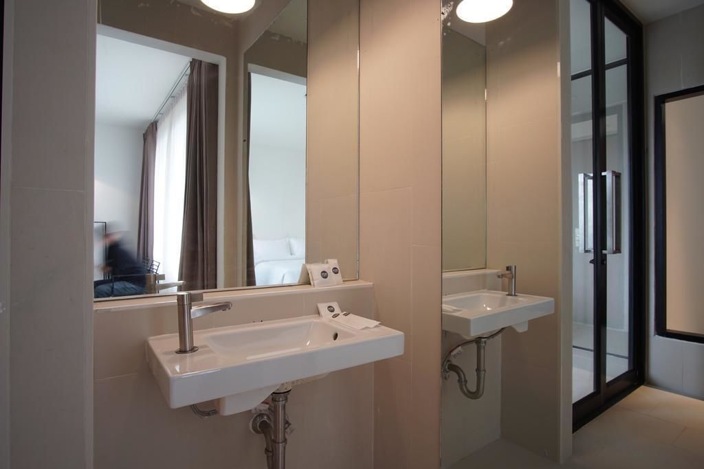 Un baño moderno con dos lavamanos, un espejo grande y una cabina de ducha de vidrio.