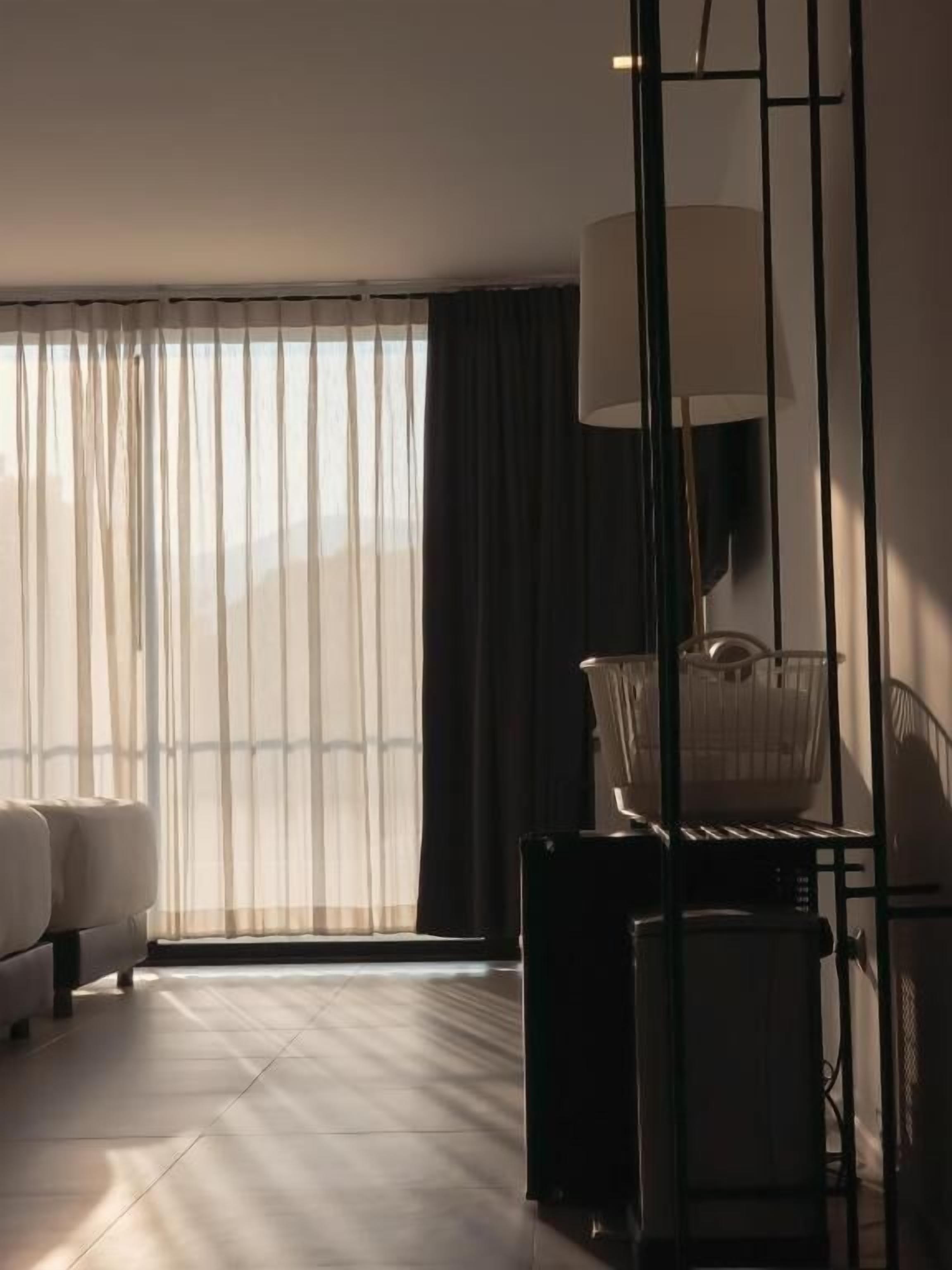 Un salón moderno con sofá, lámpara de pie y un radiador.