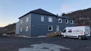 A two-story building with a grey exterior and a sloped roof. - Mosjøen Hybelhus (Vefsn)