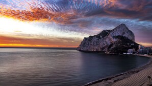 A coastal landscape with a prominent rock formation, calm sea, and a beach. - First line / Wifi / Spa / Seaviews / Heated pool / Pets (Calpe)