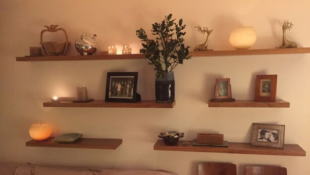 A living room with a sofa, two chairs, and multiple wooden shelves displaying various decorative items. - Stunning self contained 1 bedroom flat in the heart of Putney.  (London)