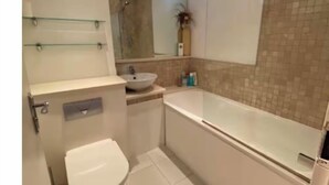 A compact bathroom with a toilet, sink, and bathtub. - Stunning self contained 1 bedroom flat in the heart of Putney.  (London)