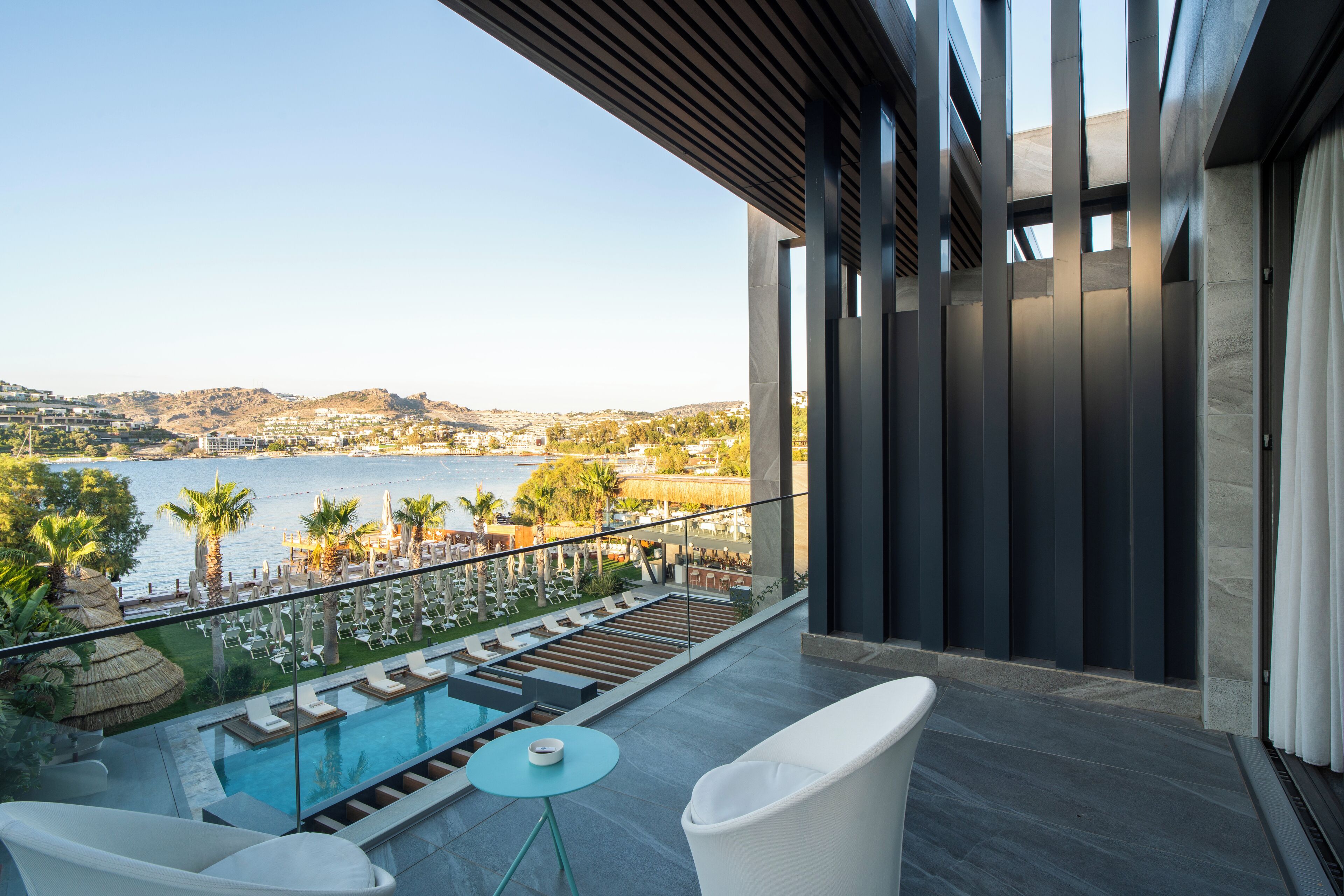 Ein Balkon mit Blick auf ein Schwimmbecken und eine Berglandschaft.
