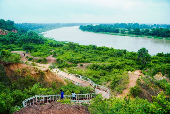 A river with a bridge and lush greenery. - Hotel Annapurna (Bishnupur)