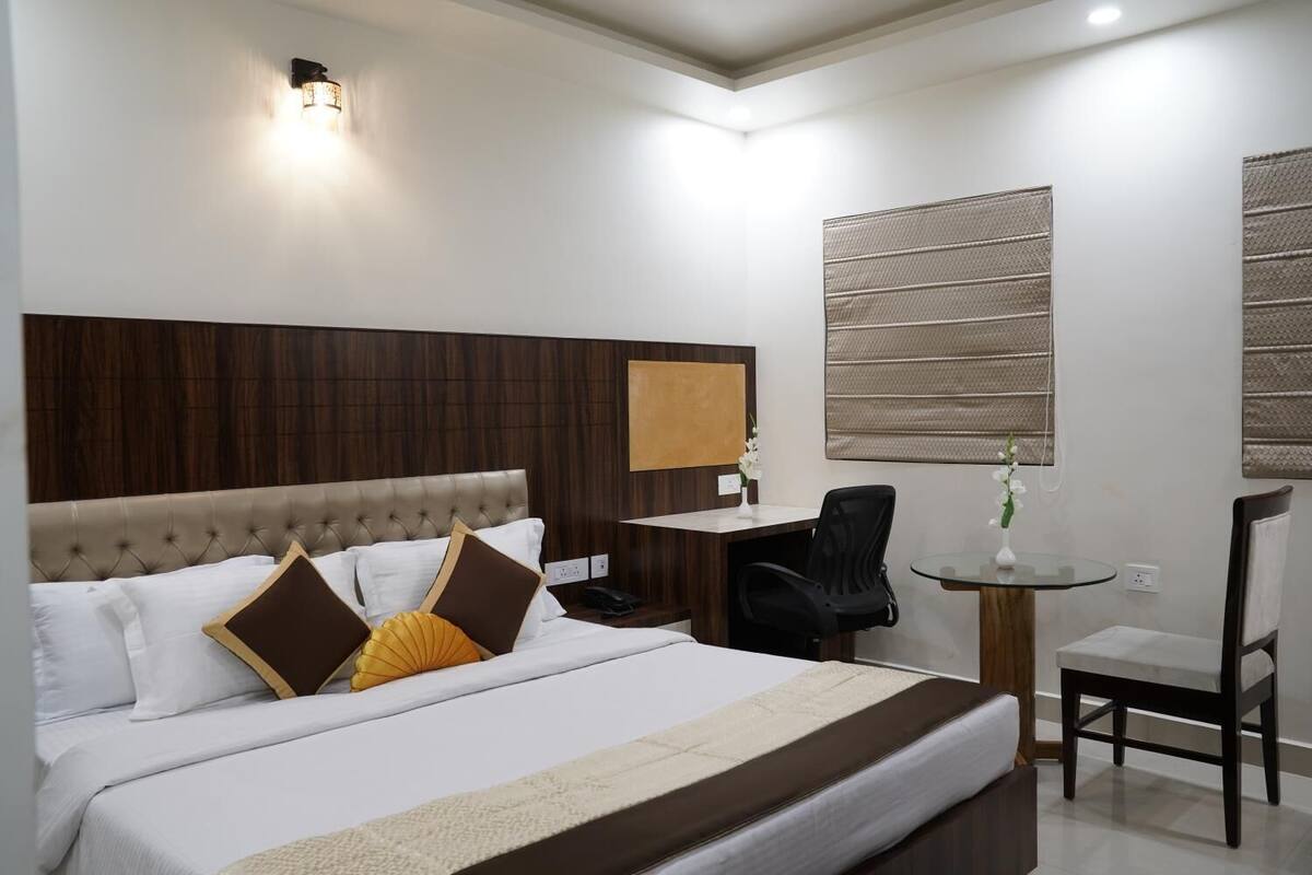 Une chambre d’hôtel avec un grand lit, un bureau, une chaise et une petite table.