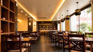 A restaurant interior with wooden furniture, a bar area, and a view of the outdoors.
