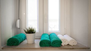 A bathroom with a window, a potted plant, and rolled towels. - Downtown Split City Apartment (Split)