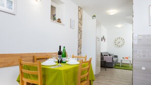 A dining area with a table set for six, a sofa, and a clock on the wall. - Downtown Split City Apartment (Split)